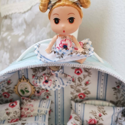 Okrúhly rozkvitnutý ňu-ňu kufrík s bábikou